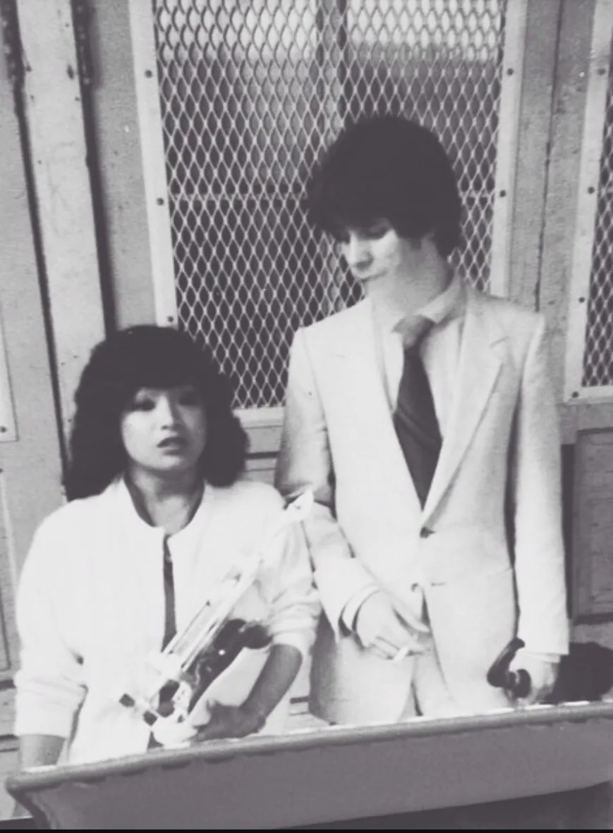 Black-and-white photo of a young couple in white suits