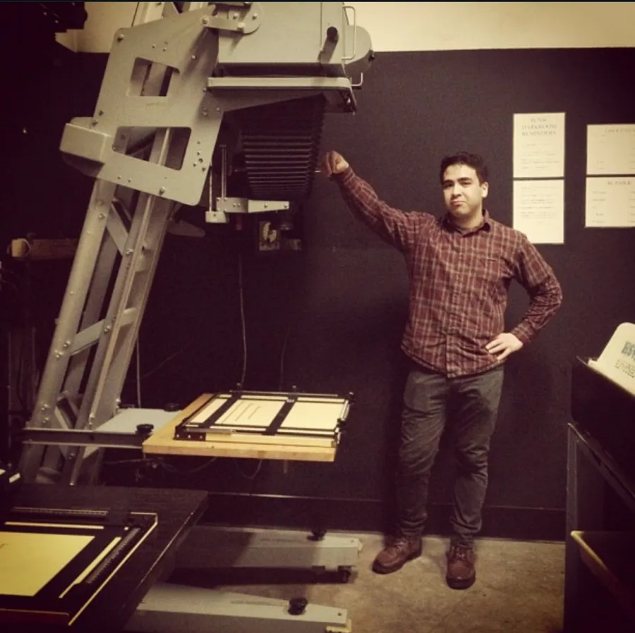 Standing beside a large reproduction camera at the studio