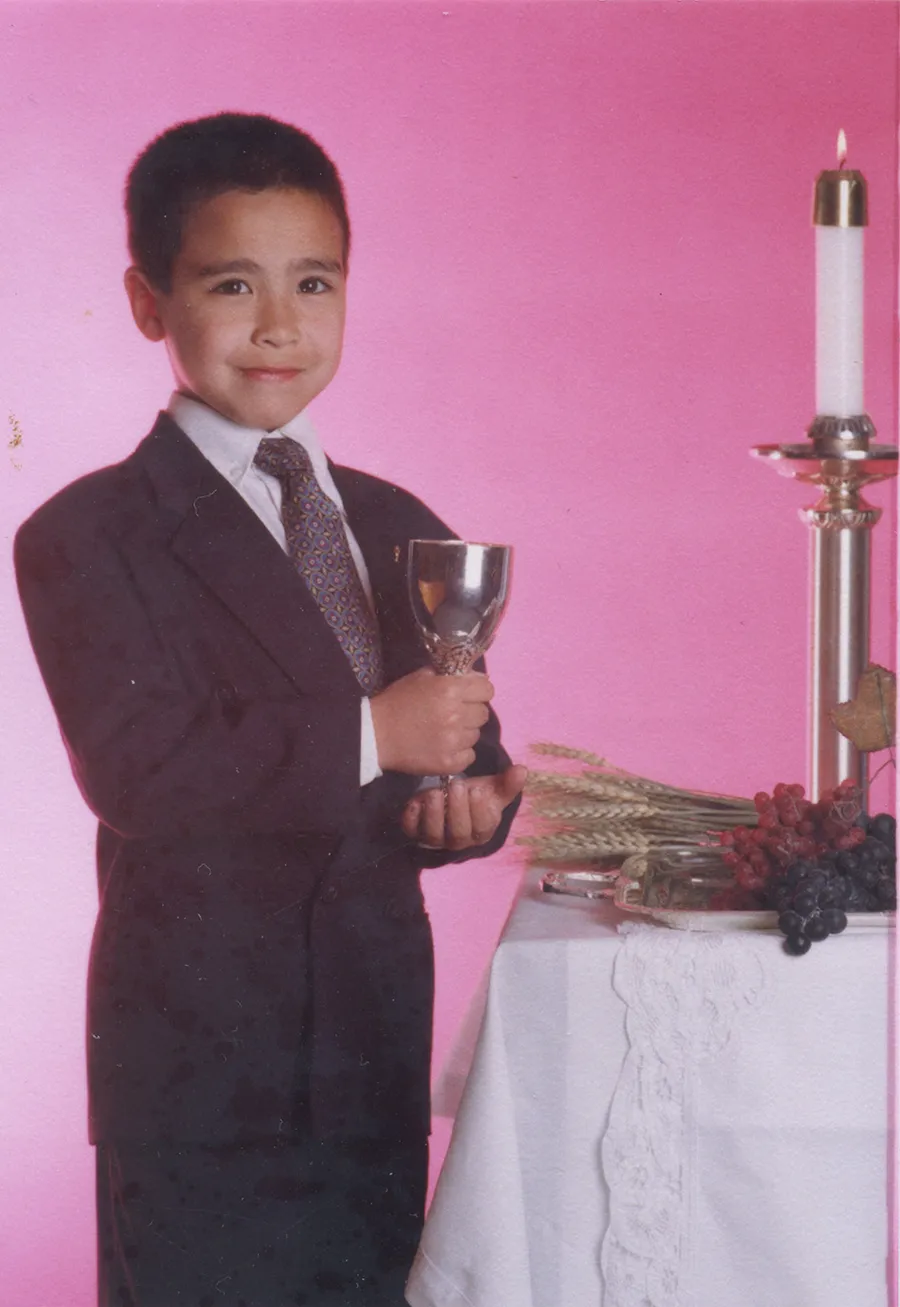 Formal portrait as a kid, in a suit against a pink backdrop