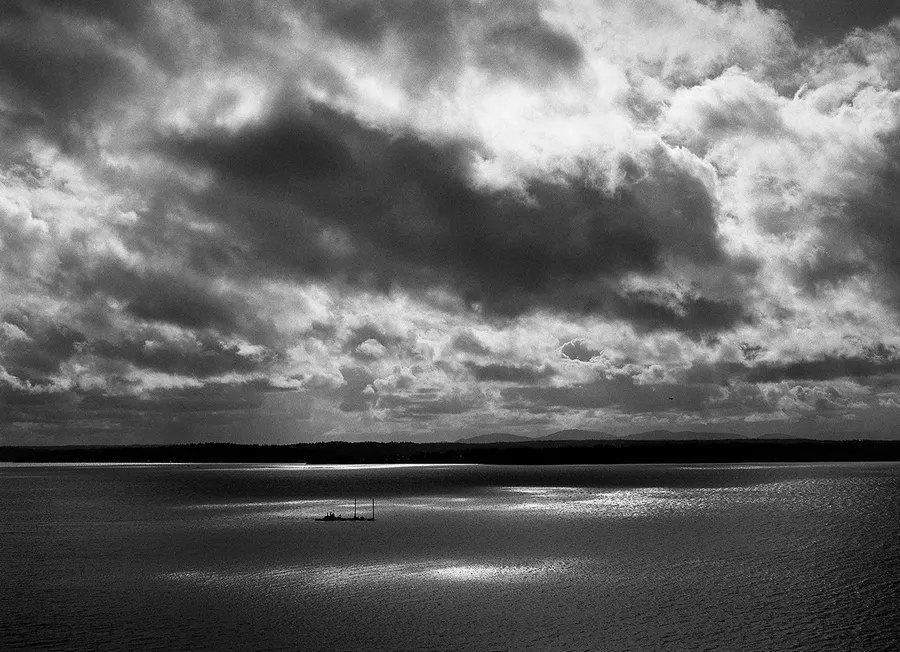 Black-and-white photograph of clouds over the water