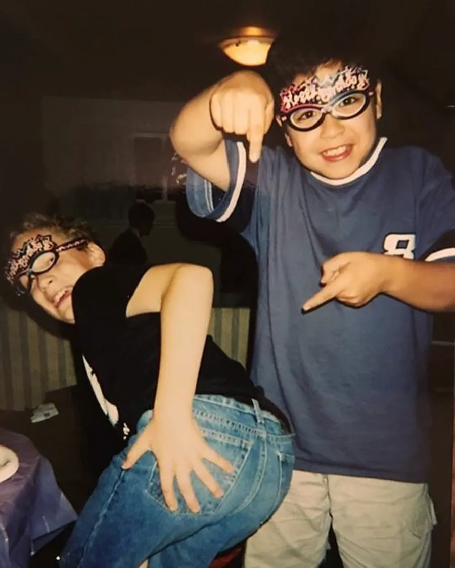 Goofing around with a friend in party hats and glasses